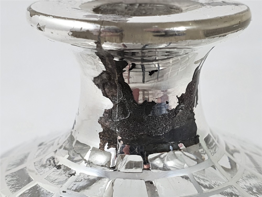 A round clear glass perfume bottle featuring a grid pattern silver overlay and a spherical silver stopper. View XI