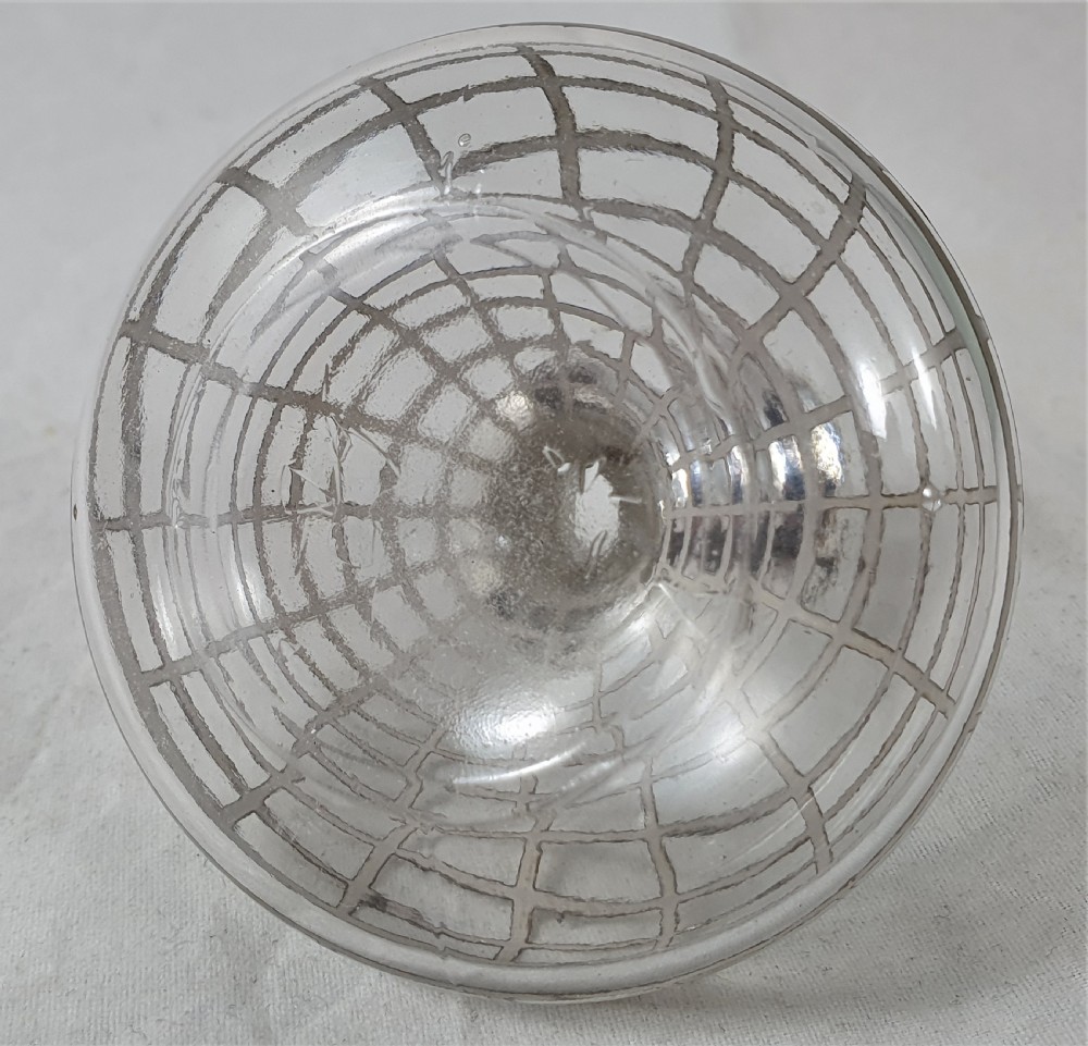 A round clear glass perfume bottle featuring a grid pattern silver overlay and a spherical silver stopper. View XII