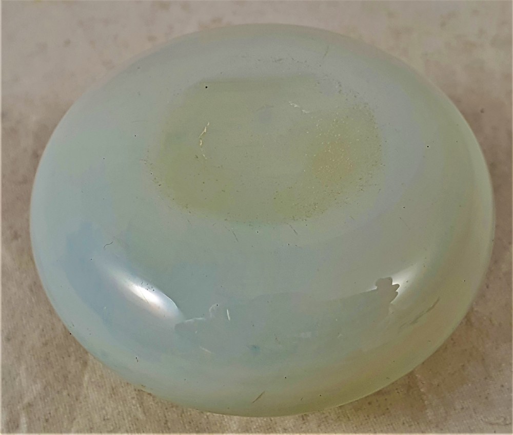 A small squat opalescent glass scent bottle featuring hand-painted gilded floral garlands around the body and a matching disc stopper. View VIII