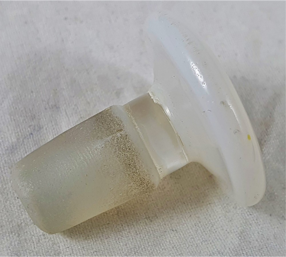 A small squat opalescent glass scent bottle featuring hand-painted gilded floral garlands around the body and a matching disc stopper. View IX