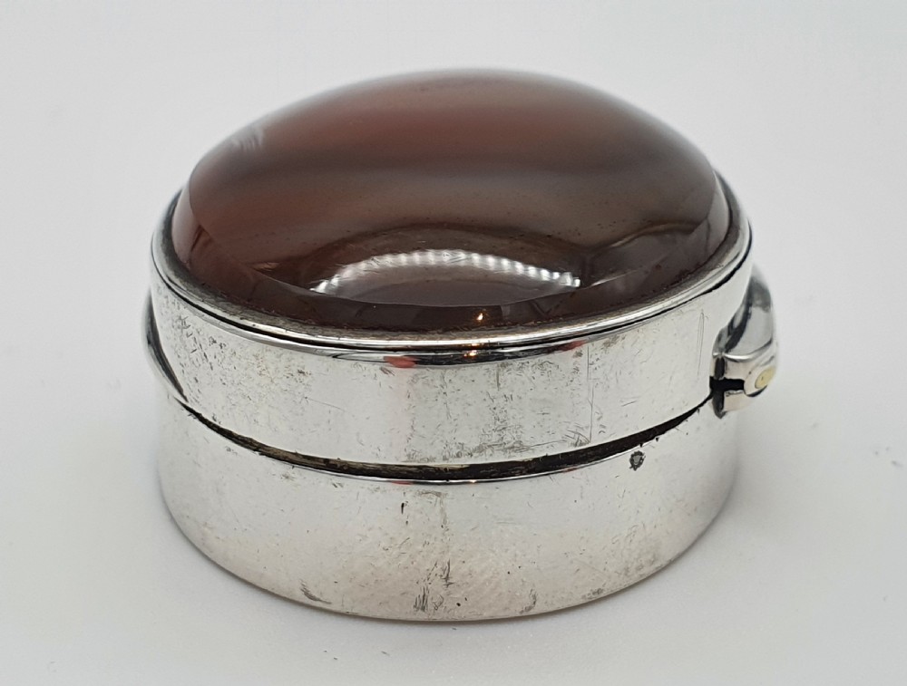 A Georgian oval silver vinaigrette featuring a smooth brown agate top and engraved script monogram on the silver collar. View IV