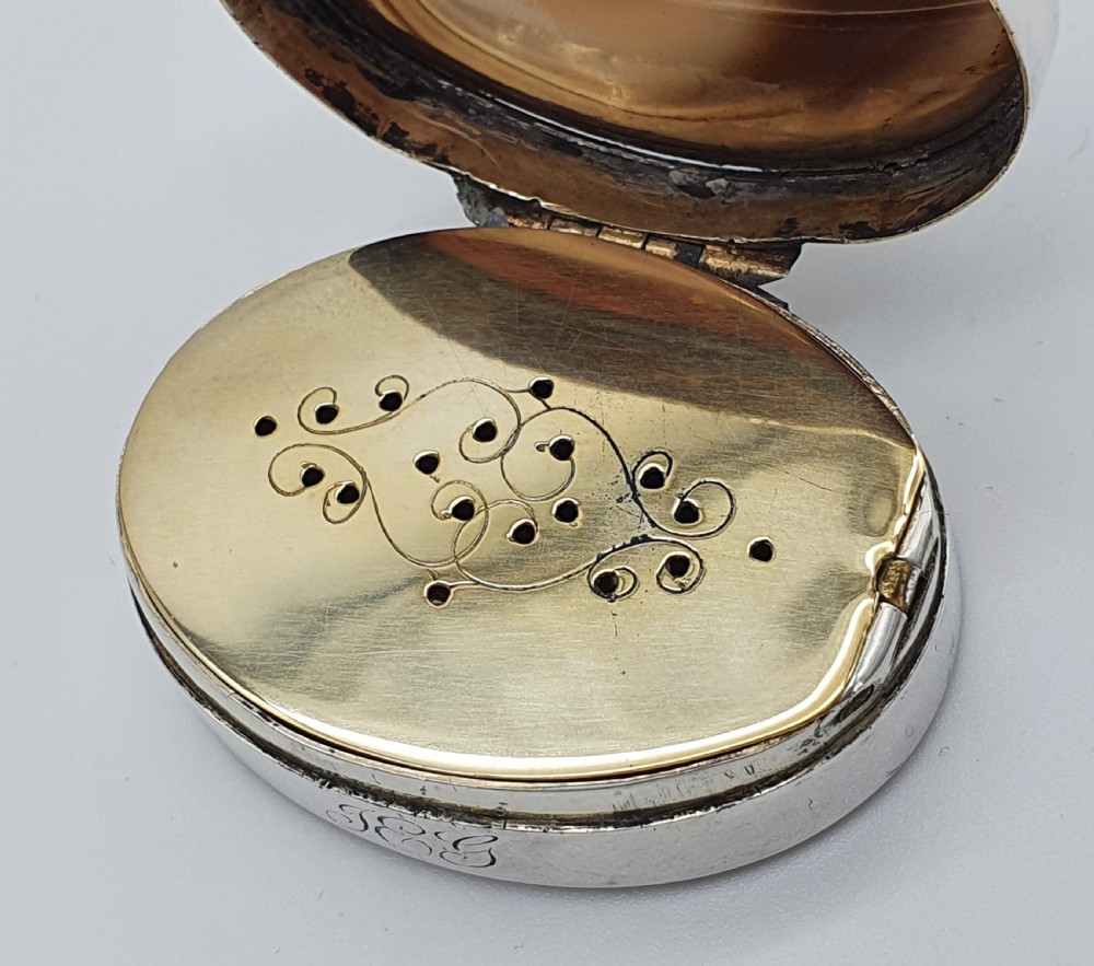 A Georgian oval silver vinaigrette featuring a smooth brown agate top and engraved script monogram on the silver collar. View X