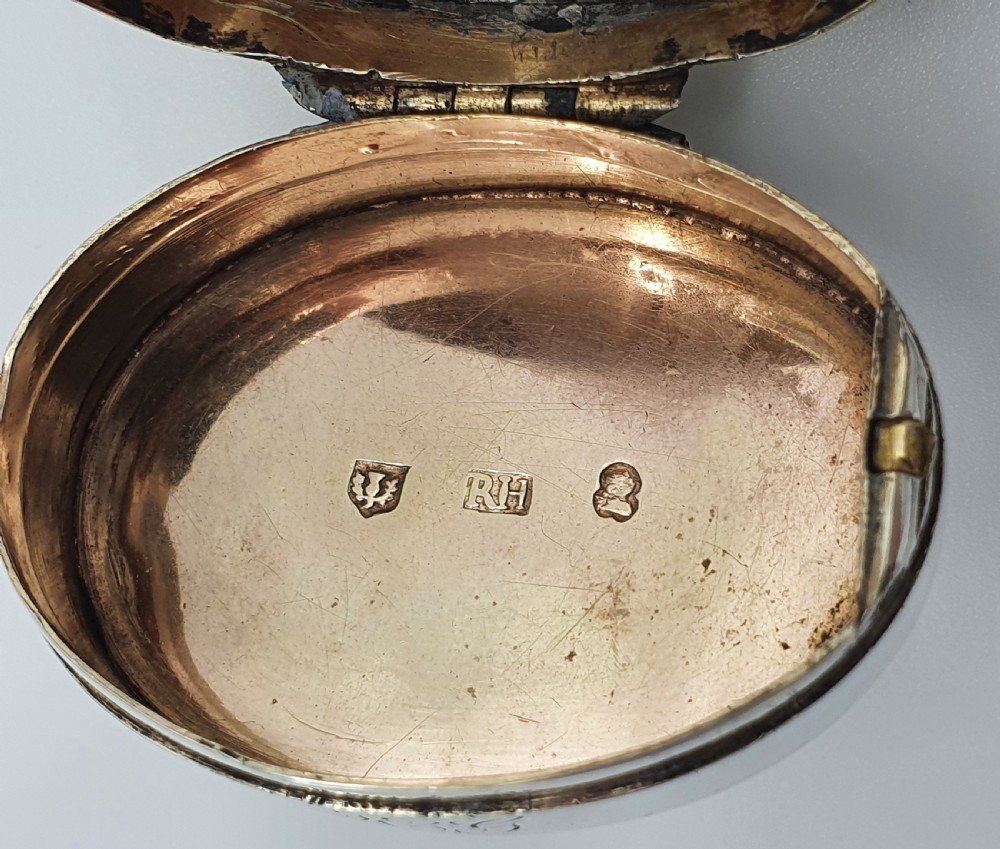 A Georgian oval silver vinaigrette featuring a smooth brown agate top and engraved script monogram on the silver collar. View XII