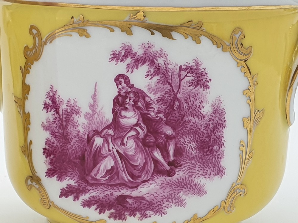 A yellow and white Dresden porcelain cache pot featuring side handles, gold gilding, and a central cartouche depicting a purple painted pastoral scene. View II