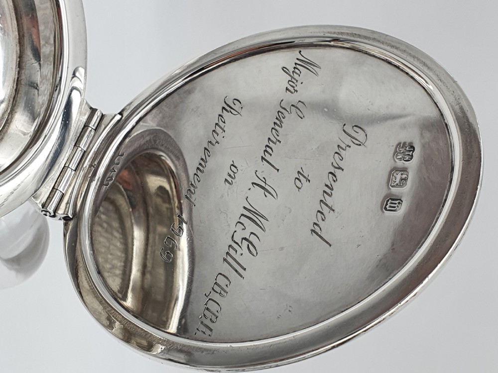 A late Victorian claret jug featuring a diamond-cut clear glass body paired with a polished sterling silver collar, hinged flat lid, fluted finial, and clear glass handle. View VIII