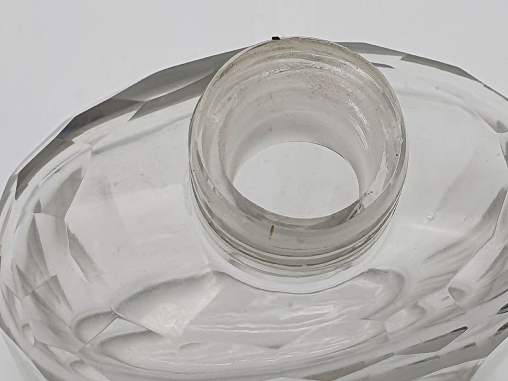 A George V clear faceted glass bottle featuring a hallmarked sterling silver collar and polished silver top cap. View XI