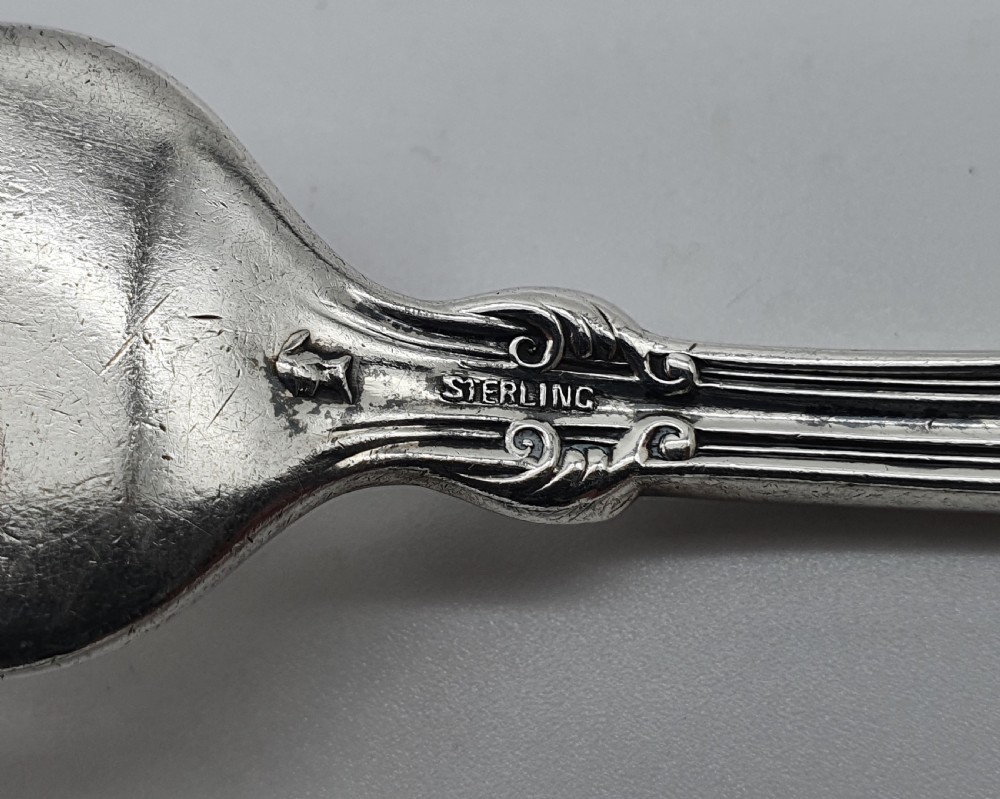 An American sterling silver table knife and matching four-tined fork featuring ornate foliate scrollwork handles. View III