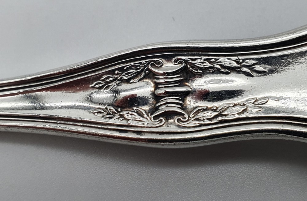 An American sterling silver table knife and matching four-tined fork featuring ornate foliate scrollwork handles. View VII