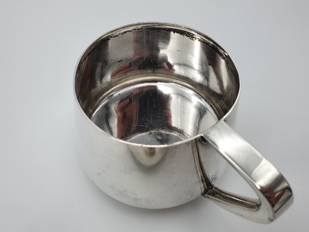 A set of four small silver vodka cups with angular handles and engraved monograms against a white backdrop. View IX