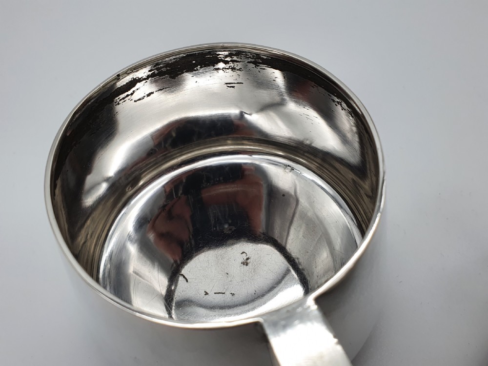 A set of four small silver vodka cups with angular handles and engraved monograms against a white backdrop. View XI