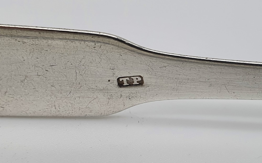 A pair of George III sterling silver sugar tongs featuring smooth spoon-shaped bowls and a curved bow hinge with makers mark TP. View VIII
