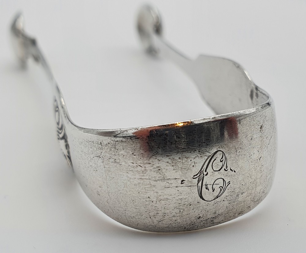 A pair of Victorian silver sugar tongs featuring shell motifs and spoon-shaped grips. View III