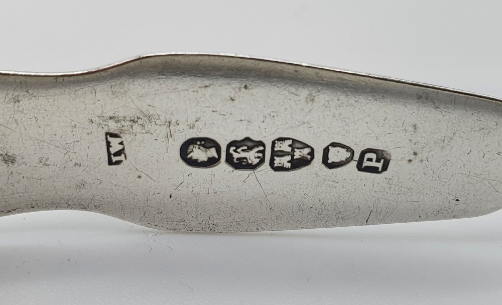 A pair of Victorian silver sugar tongs featuring shell motifs and spoon-shaped grips. View VI