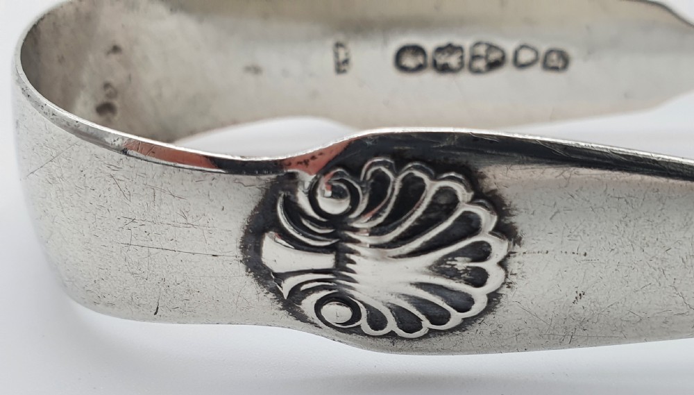 A pair of Victorian silver sugar tongs featuring shell motifs and spoon-shaped grips. View VIII
