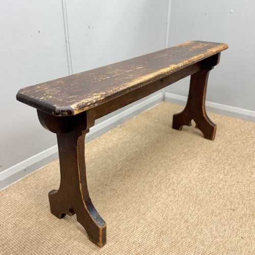 fig 1. A five-foot antique pine bench featuring a distressed dark brown finish and shaped slab end supports.