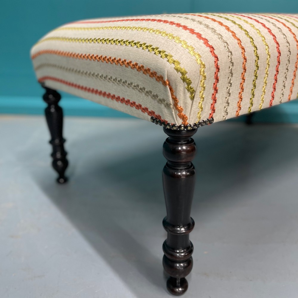 Newly upholstered ottoman stool on ebonised legs  View II