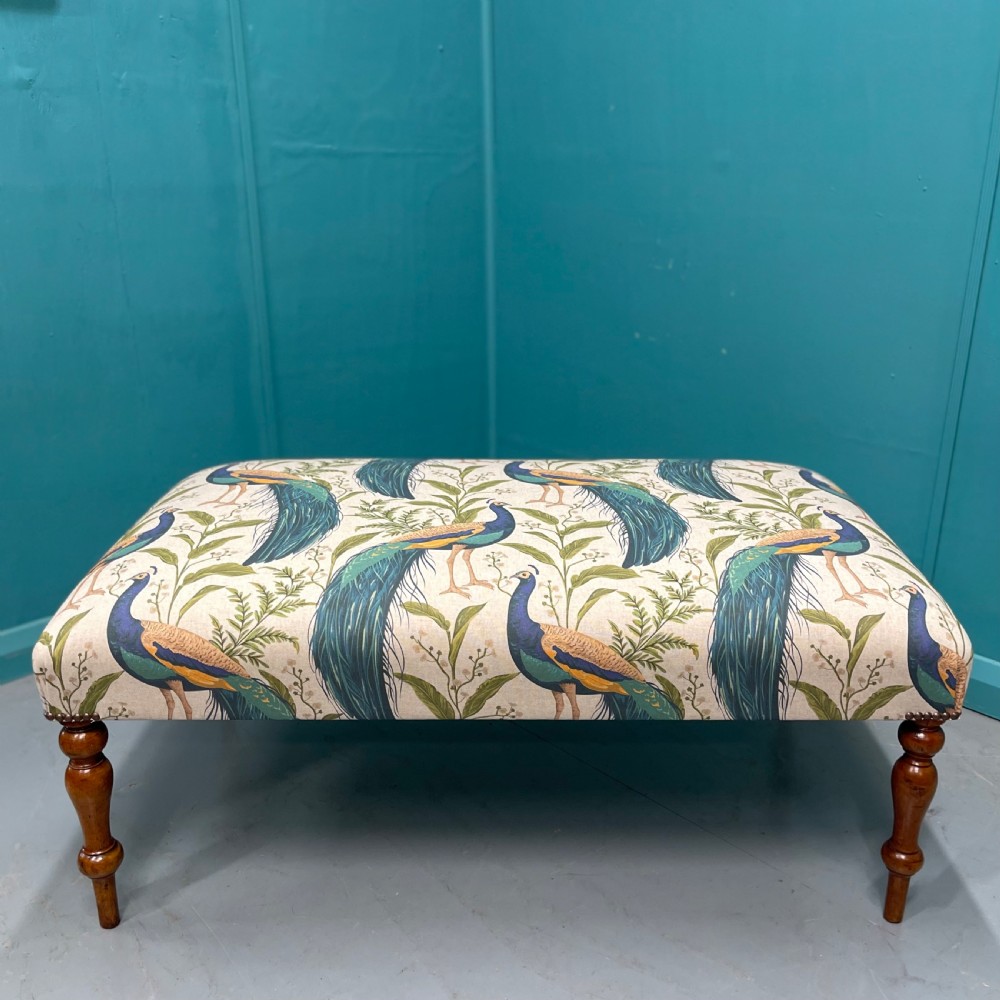 Newly upholstered ottoman footstool with peacocks