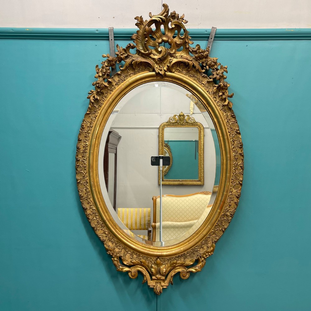 Large French oval gilt mirror with bevelled glass