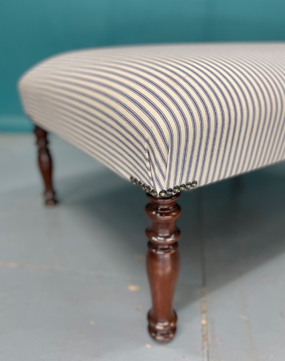 Newly upholstered blue ticking stripe footstool View V