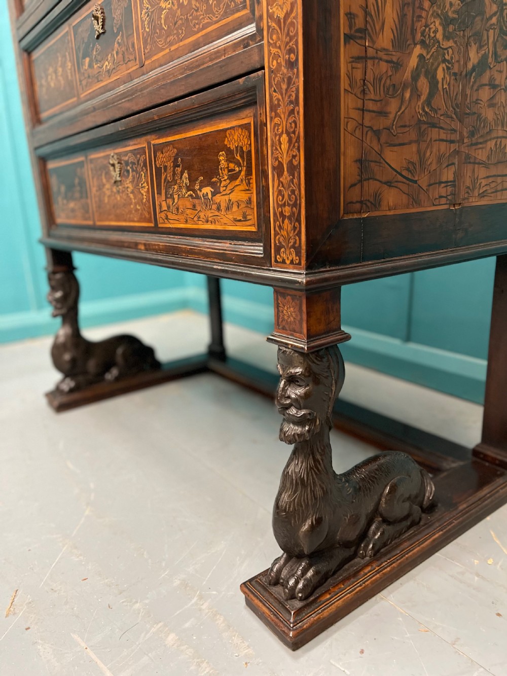 A nineteenth-century Italian walnut chest featuring three drawers decorated with detailed marquetry pictorial scenes and resting on carved base supports. View II