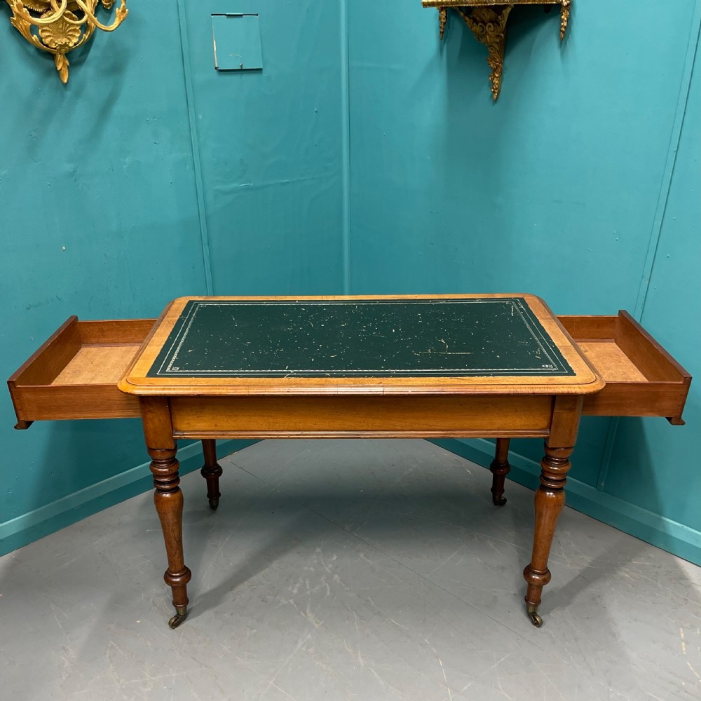 A rectangular Victorian timber library table featuring a green leather insert top with gold tooling, turned legs, and brass castors. View II