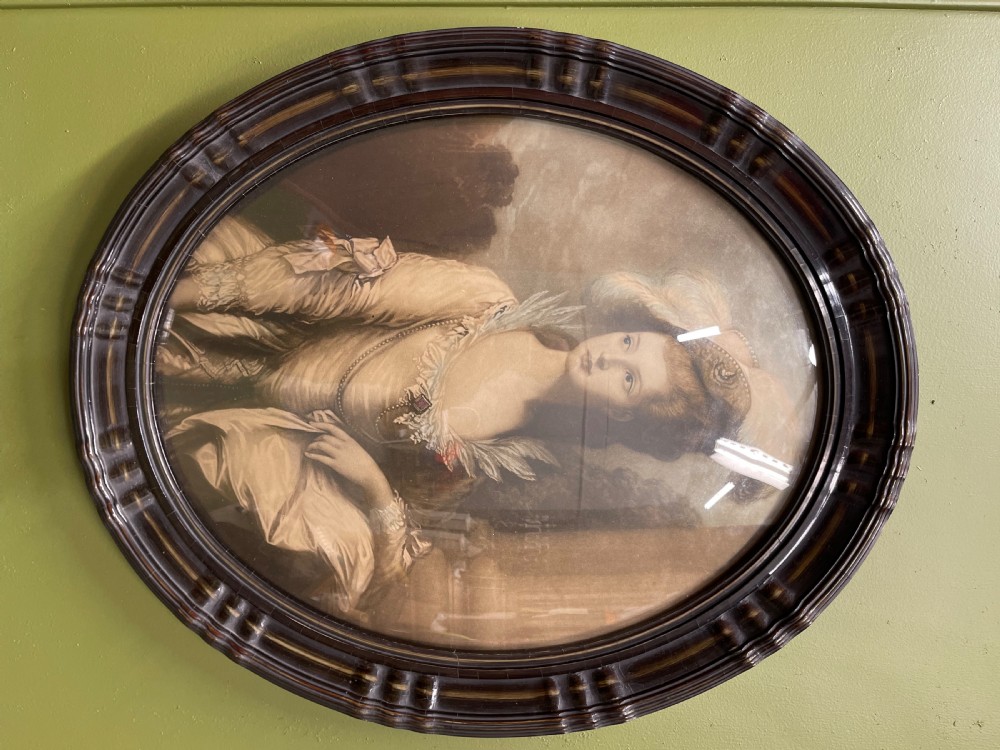 A pair of matching oval portraits featuring 18th-century style figures, housed under convex glass within dark moulded frames. View III