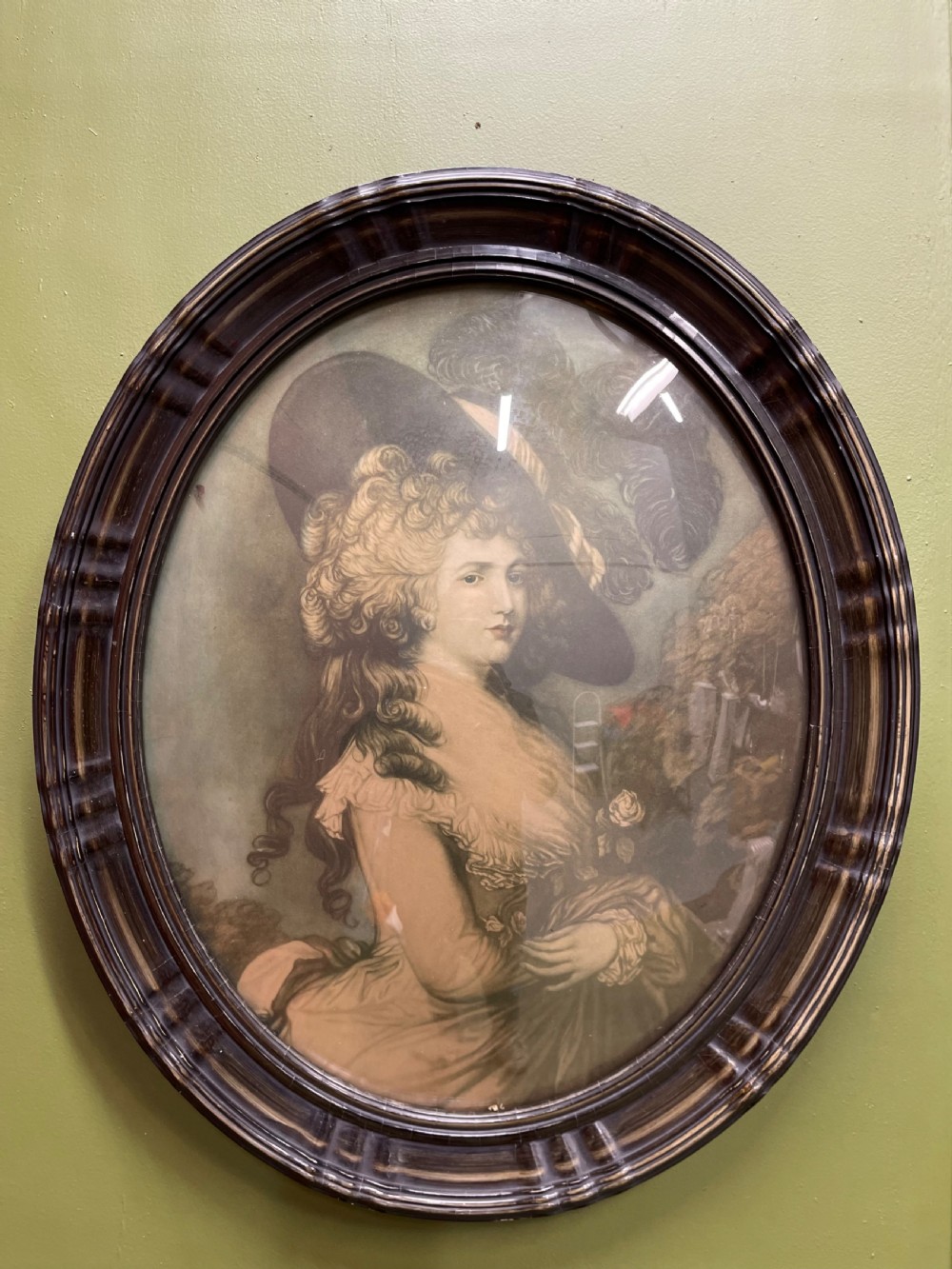 A pair of matching oval portraits featuring 18th-century style figures, housed under convex glass within dark moulded frames. View IV