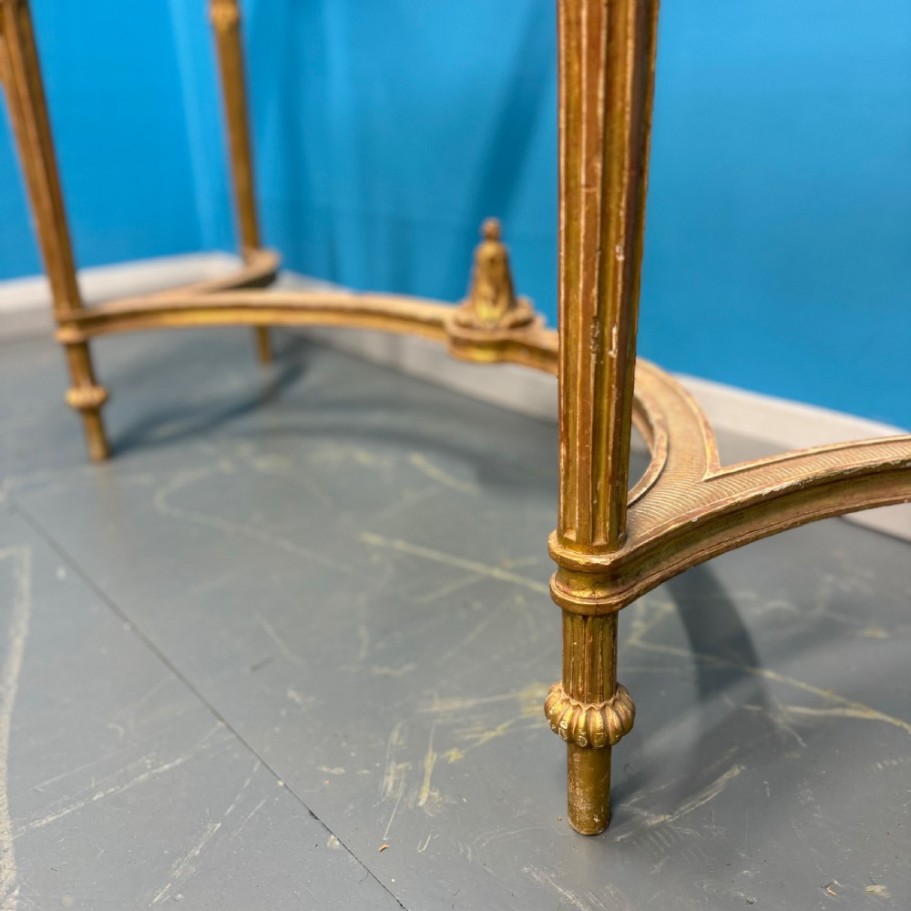 An Adam style giltwood console table featuring a dark green marble top, fluted frieze with swag carvings, and slender tapered legs. View VIII