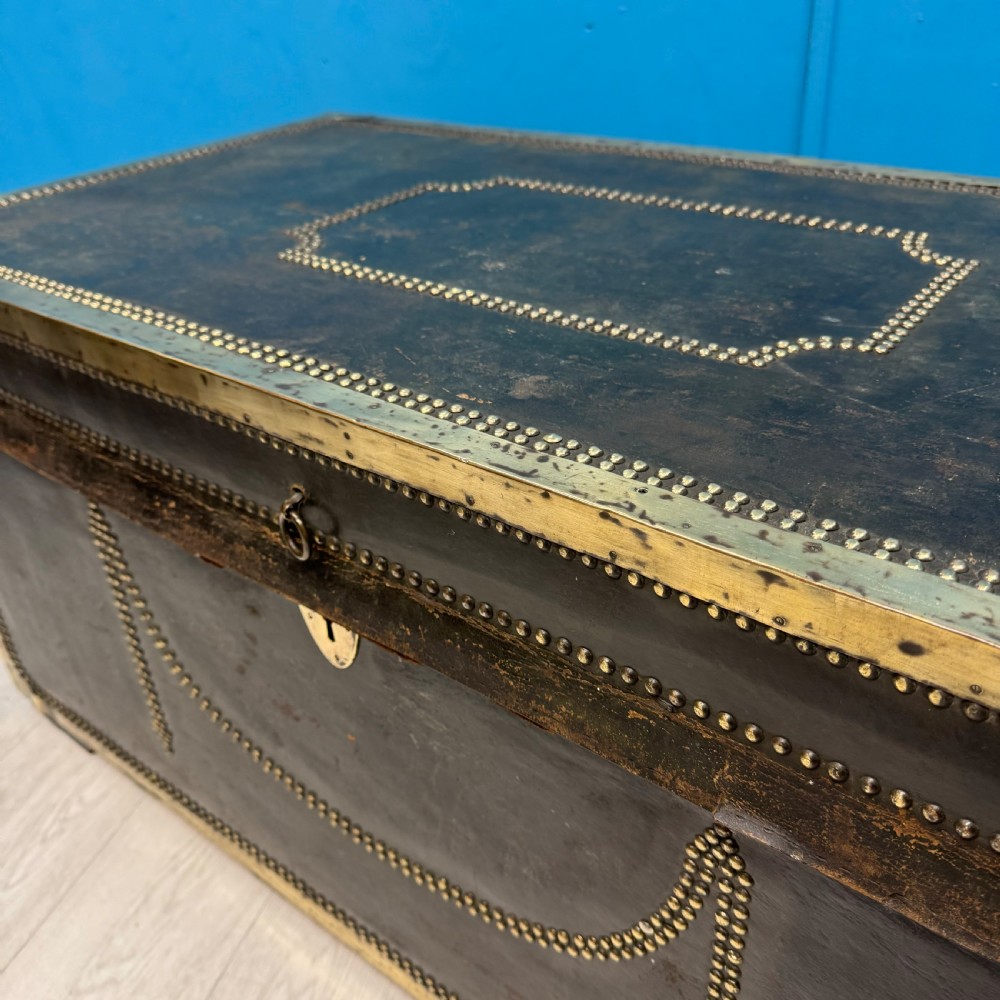 A 19th-century dark leather storage trunk featuring brass studding in geometric patterns, corner brackets, and drop handles. View II