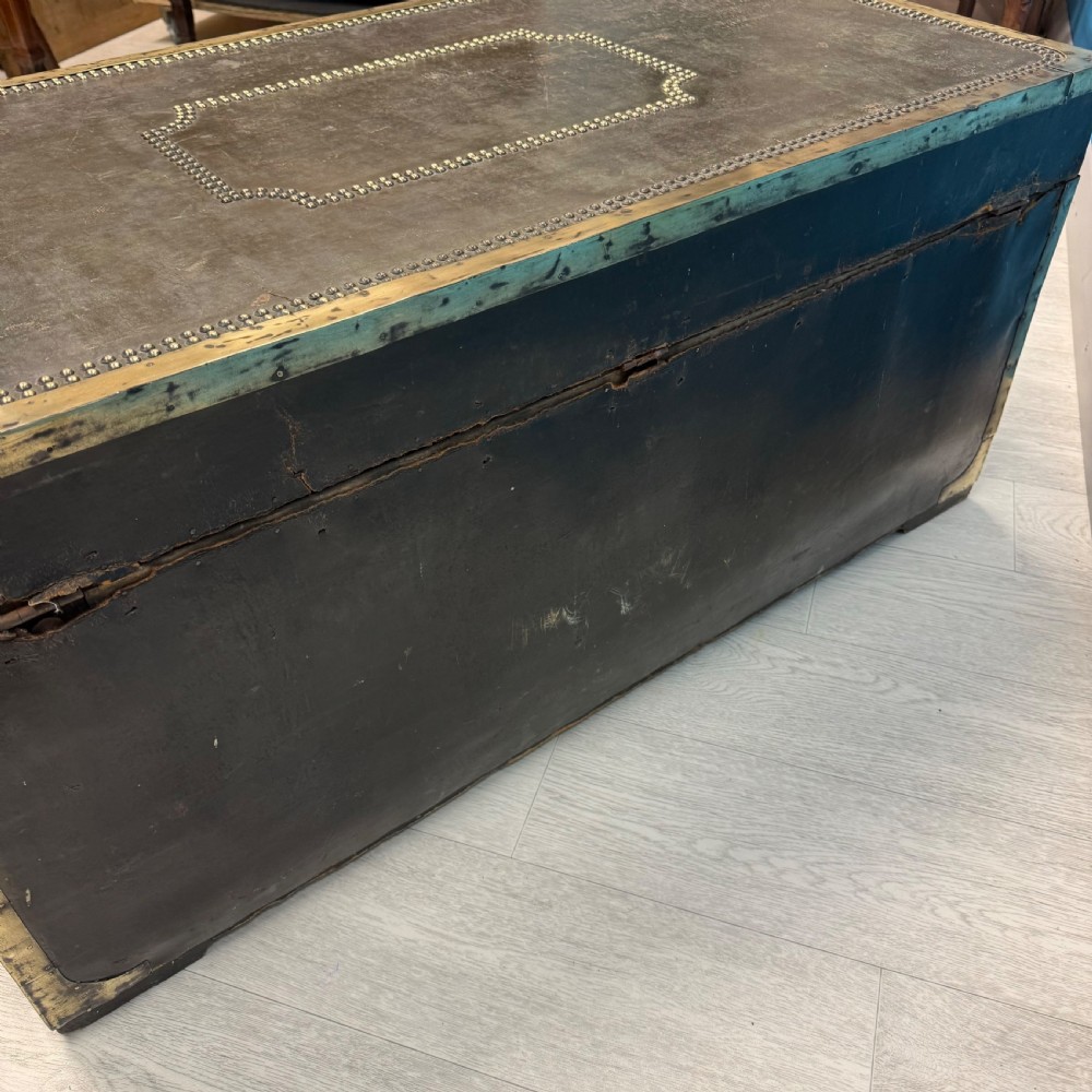 A 19th-century dark leather storage trunk featuring brass studding in geometric patterns, corner brackets, and drop handles. View VIII
