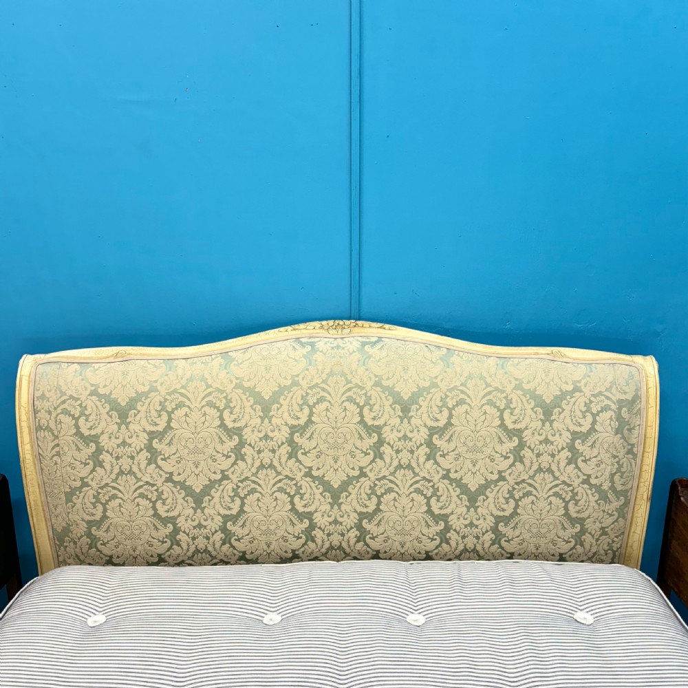 A king-size French bed frame featuring a carved cream-painted timber frame upholstered in green damask fabric with a scroll-end footboard. View VI