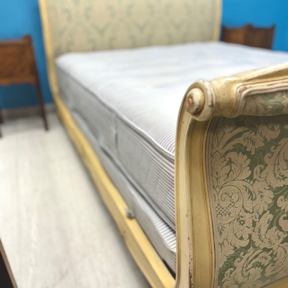 A king-size French bed frame featuring a carved cream-painted timber frame upholstered in green damask fabric with a scroll-end footboard. View VIII
