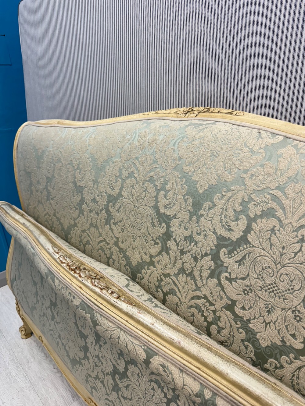 A king-size French bed frame featuring a carved cream-painted timber frame upholstered in green damask fabric with a scroll-end footboard. View XI