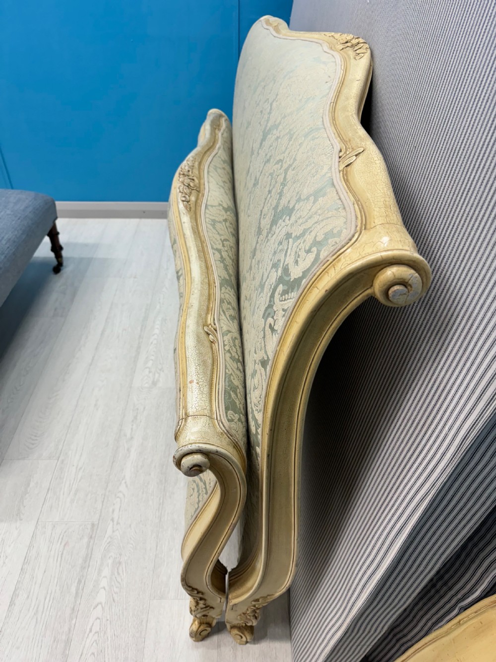 A king-size French bed frame featuring a carved cream-painted timber frame upholstered in green damask fabric with a scroll-end footboard. View XII