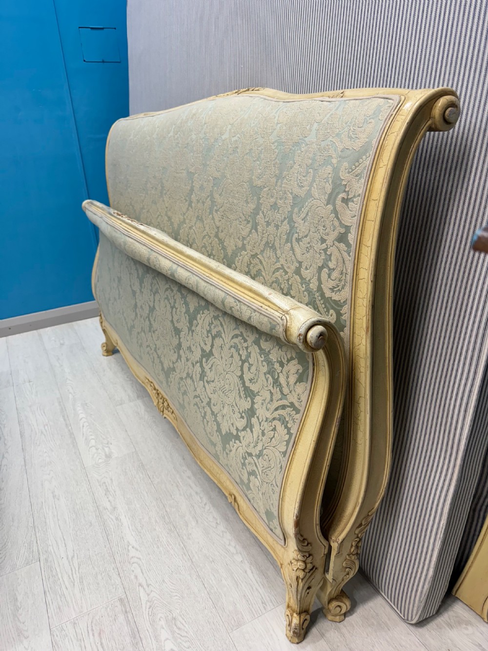 A king-size French bed frame featuring a carved cream-painted timber frame upholstered in green damask fabric with a scroll-end footboard. View XIII
