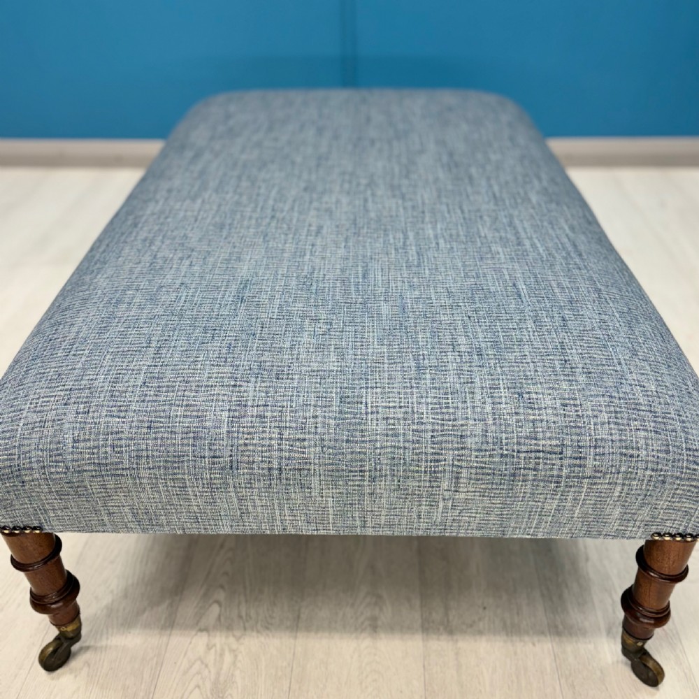 Large newly upholstered footstool on Regency legs with castors  View IV