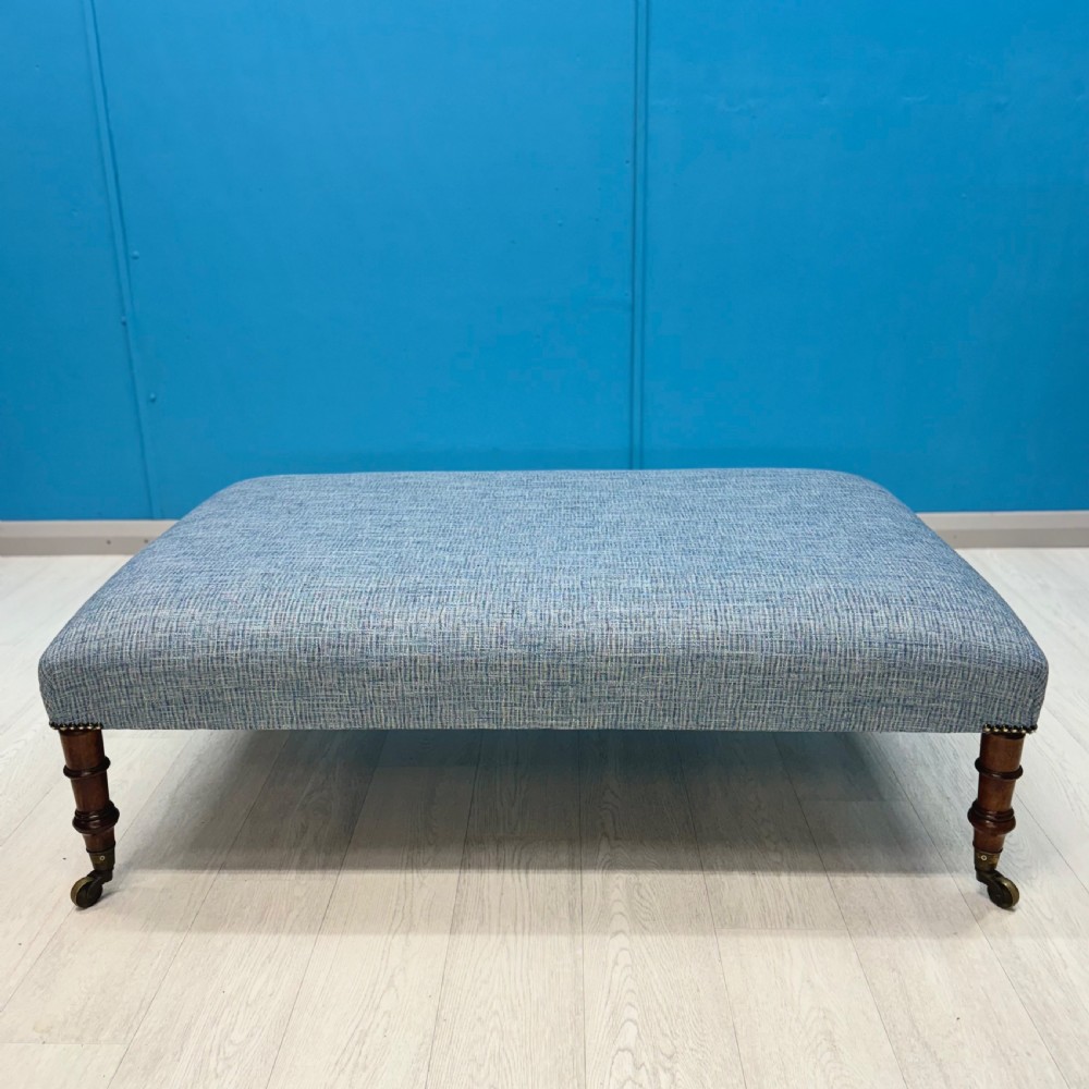 Large newly upholstered footstool on Regency legs with castors  View V