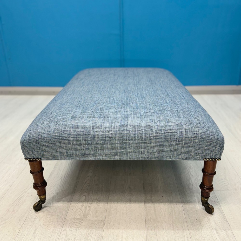Large newly upholstered footstool on Regency legs with castors  View VI