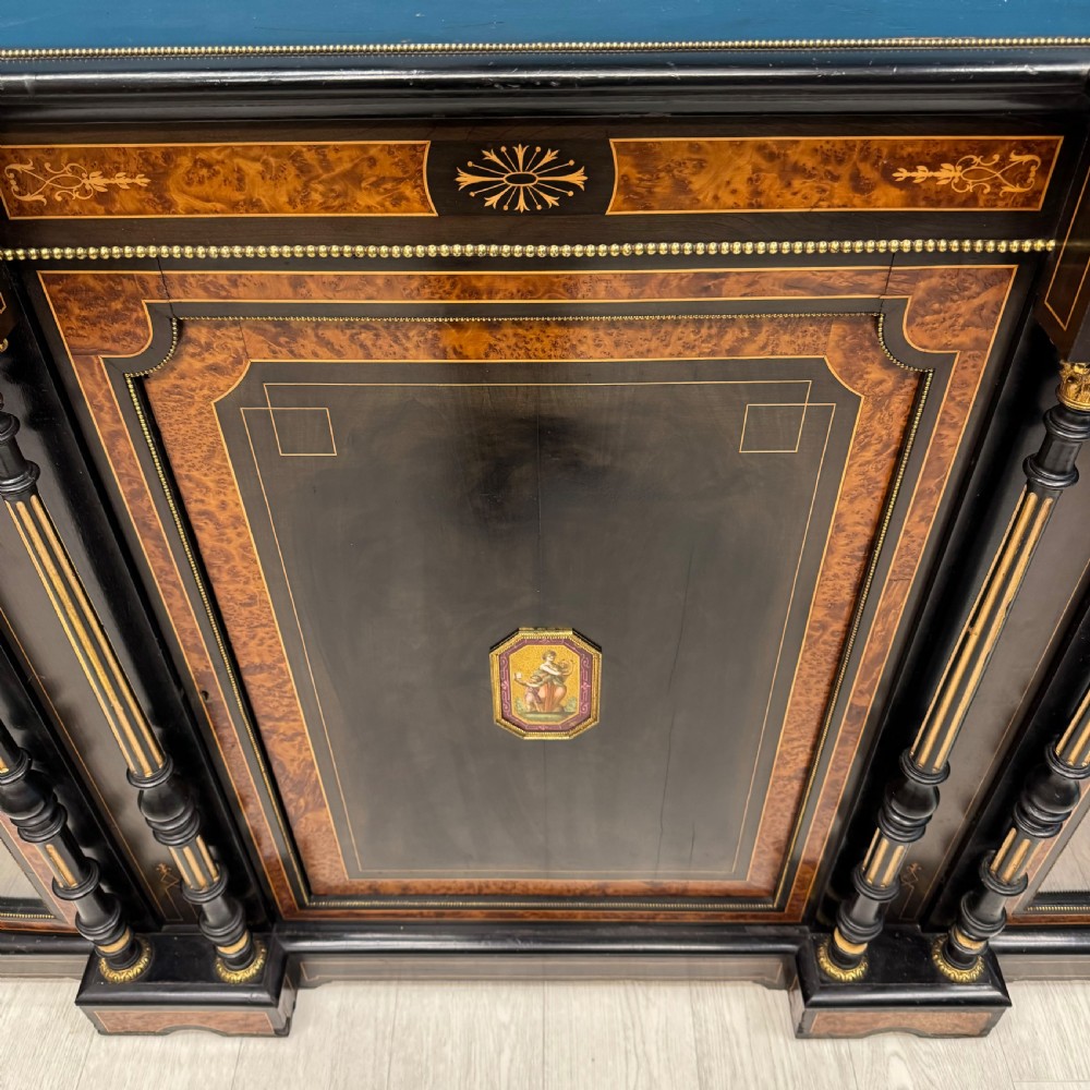 A Victorian ebonised credenza featuring a central inlaid panel door flanked by two glazed display compartments with brass mounts and fluted column details. View II