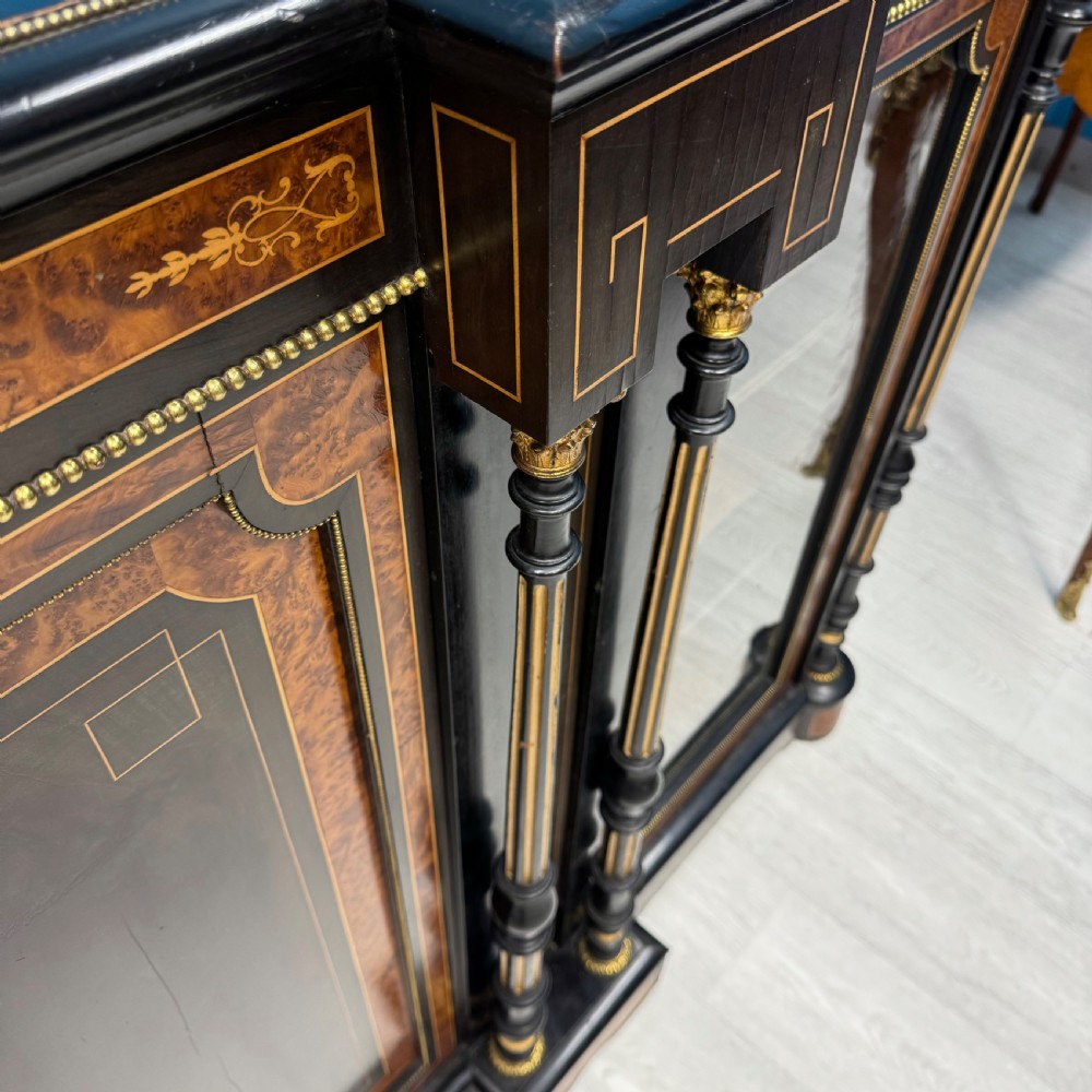A Victorian ebonised credenza featuring a central inlaid panel door flanked by two glazed display compartments with brass mounts and fluted column details. View III