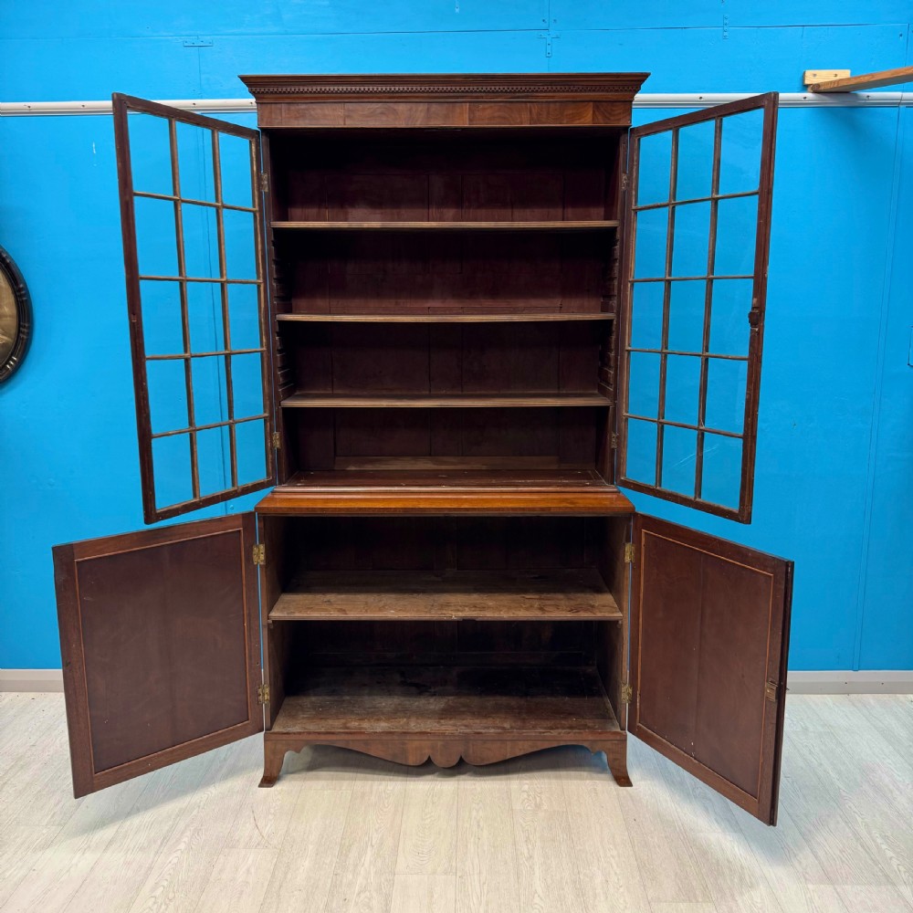 An antique Regency flame mahogany two-part bookcase featuring a glazed upper section with astragal bars and a double cupboard base. View III