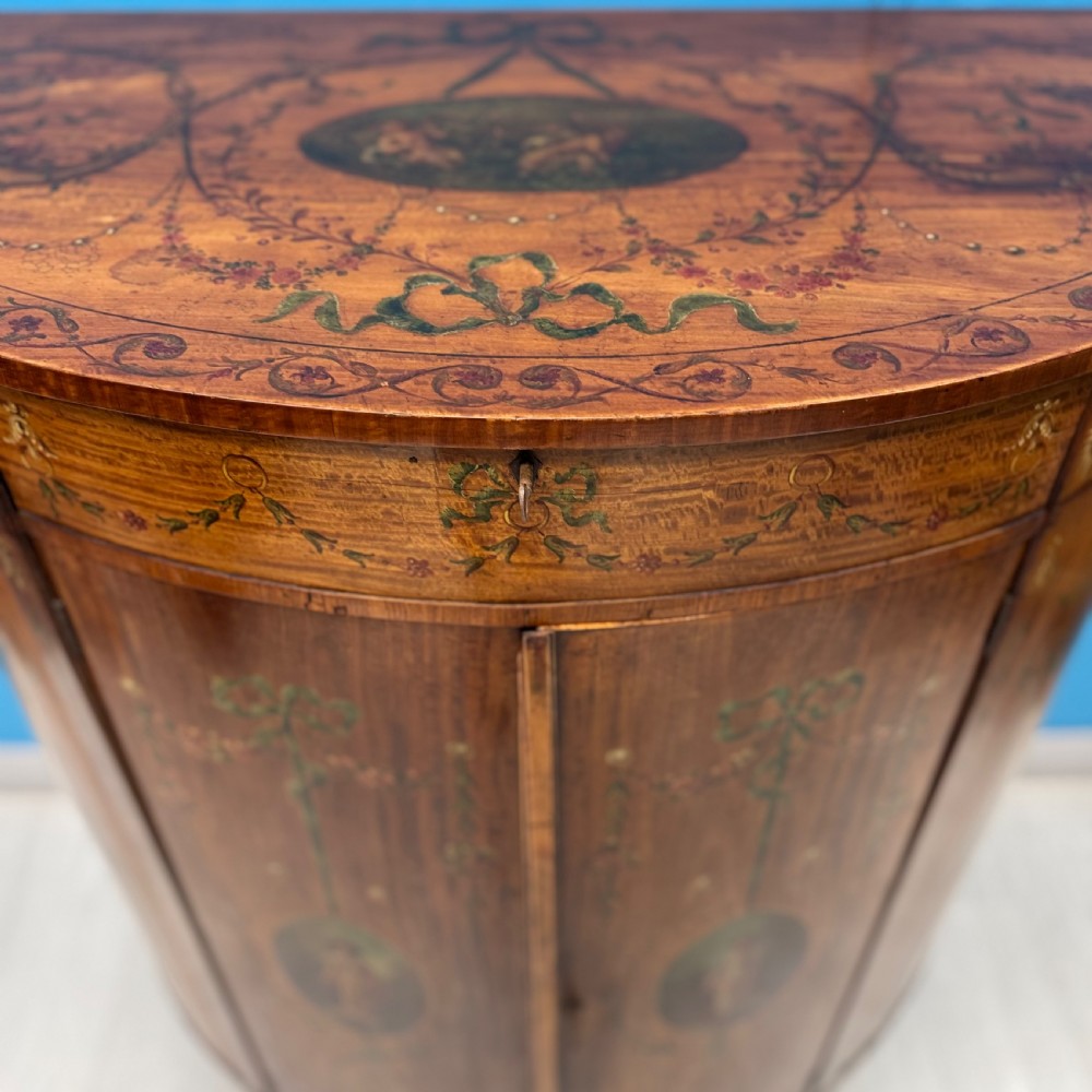 A 19th-century demi-lune satinwood side cabinet featuring hand-painted floral swags, ribbon motifs, and portrait medallions across its curved front doors. View IV
