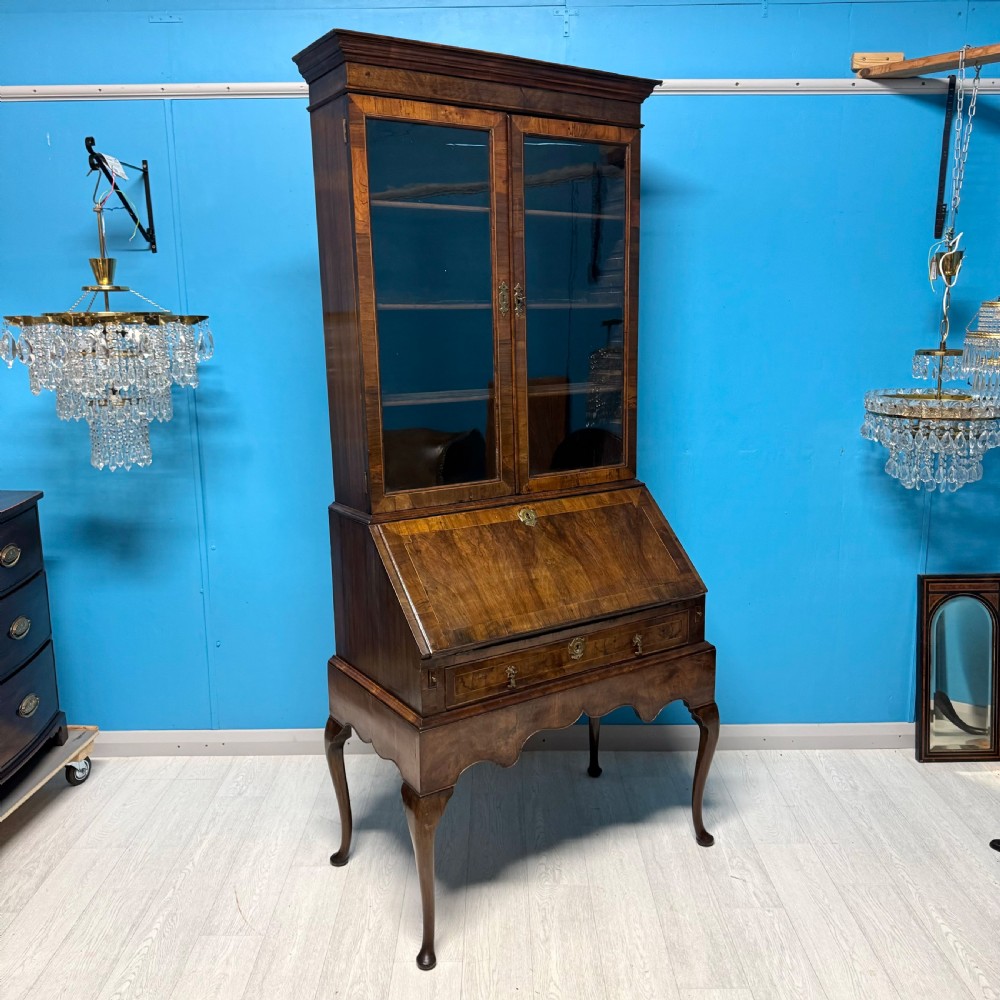 A George II walnut bureau bookcase on stand featuring a two-door glazed upper display cabinet and a slant-front writing desk over cabriole legs. View V