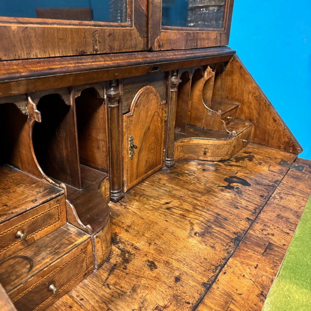 A George II walnut bureau bookcase on stand featuring a two-door glazed upper display cabinet and a slant-front writing desk over cabriole legs. View VI