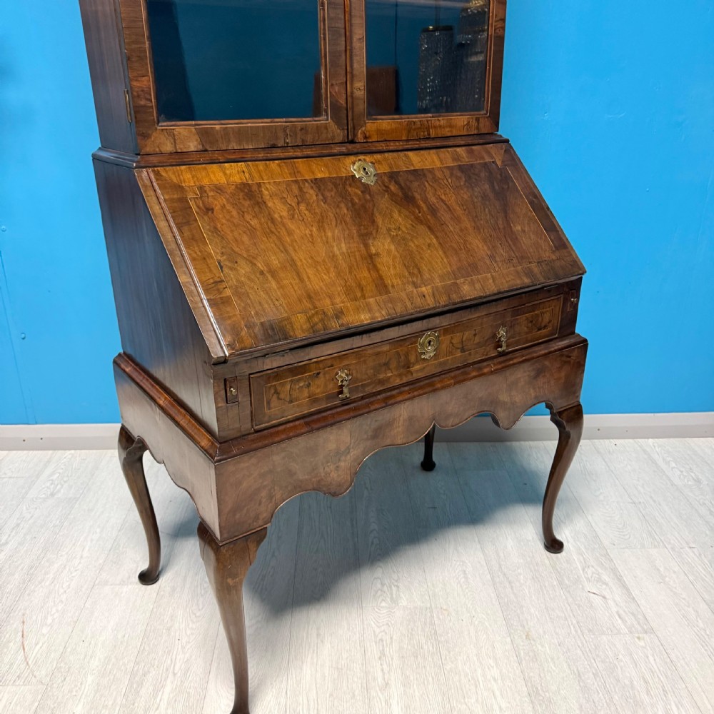 A George II walnut bureau bookcase on stand featuring a two-door glazed upper display cabinet and a slant-front writing desk over cabriole legs. View VIII
