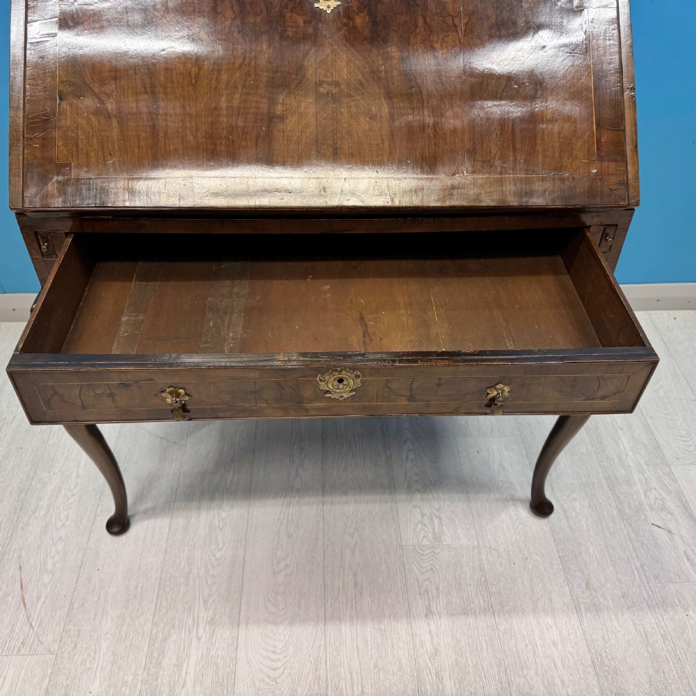 A George II walnut bureau bookcase on stand featuring a two-door glazed upper display cabinet and a slant-front writing desk over cabriole legs. View X