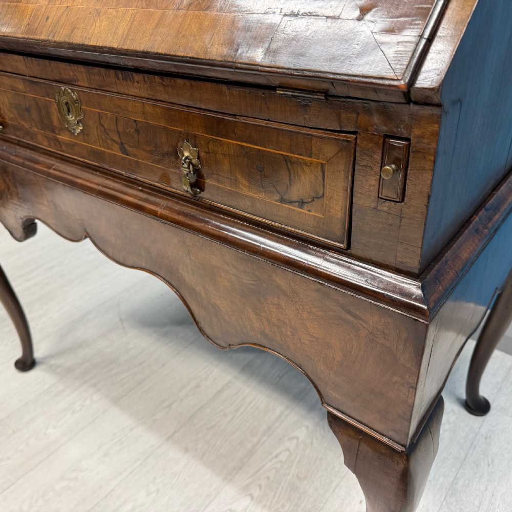 A George II walnut bureau bookcase on stand featuring a two-door glazed upper display cabinet and a slant-front writing desk over cabriole legs. View XV