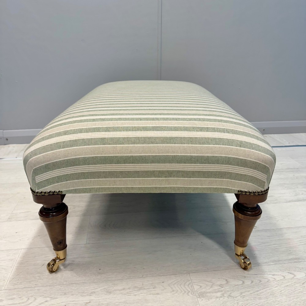 Upholstered French footstool on brass castors View III