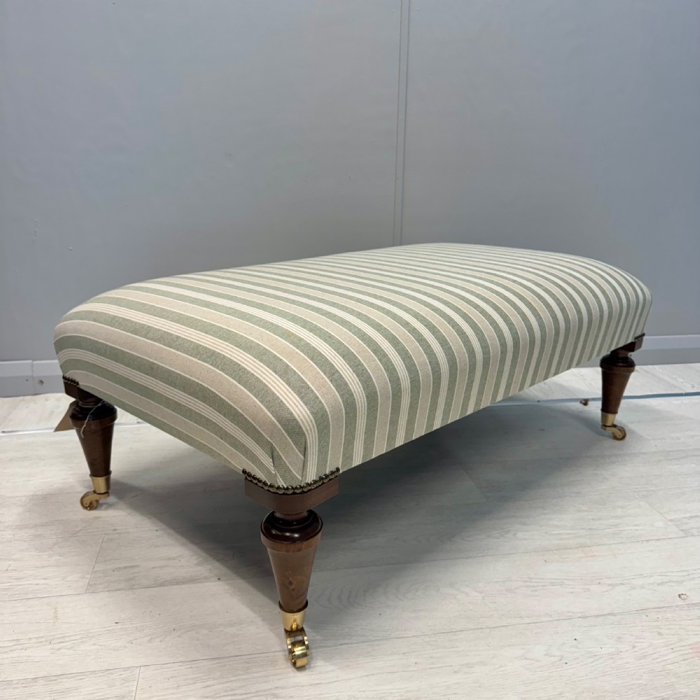 Upholstered French footstool on brass castors View V