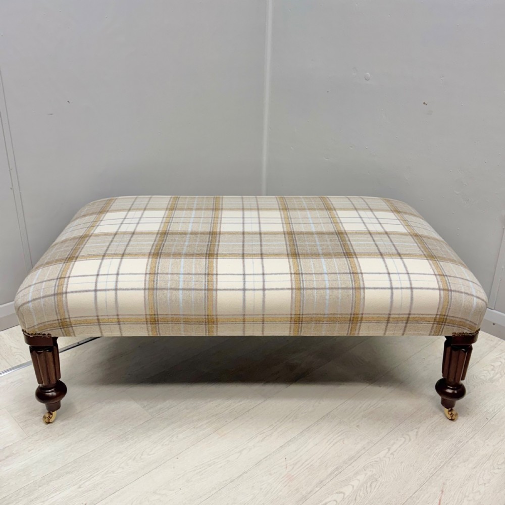 Large newly upholstered footstool on castors View III